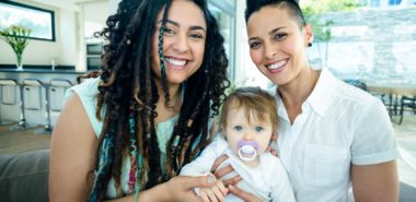 This is a portrait of a lesbian couple with their baby representing the need for a Chicago non-traditional family law attorney.