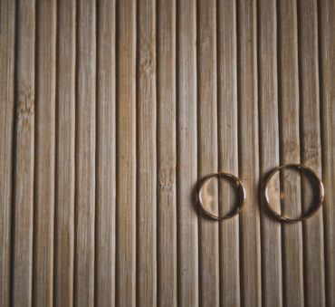 Two wedding rings sit on a wooden table after their owners met with a Chicago divorce attorney.