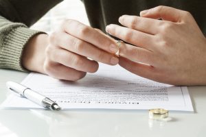 Woman taking off wedding ring before calling a downers grove divorce lawyer
