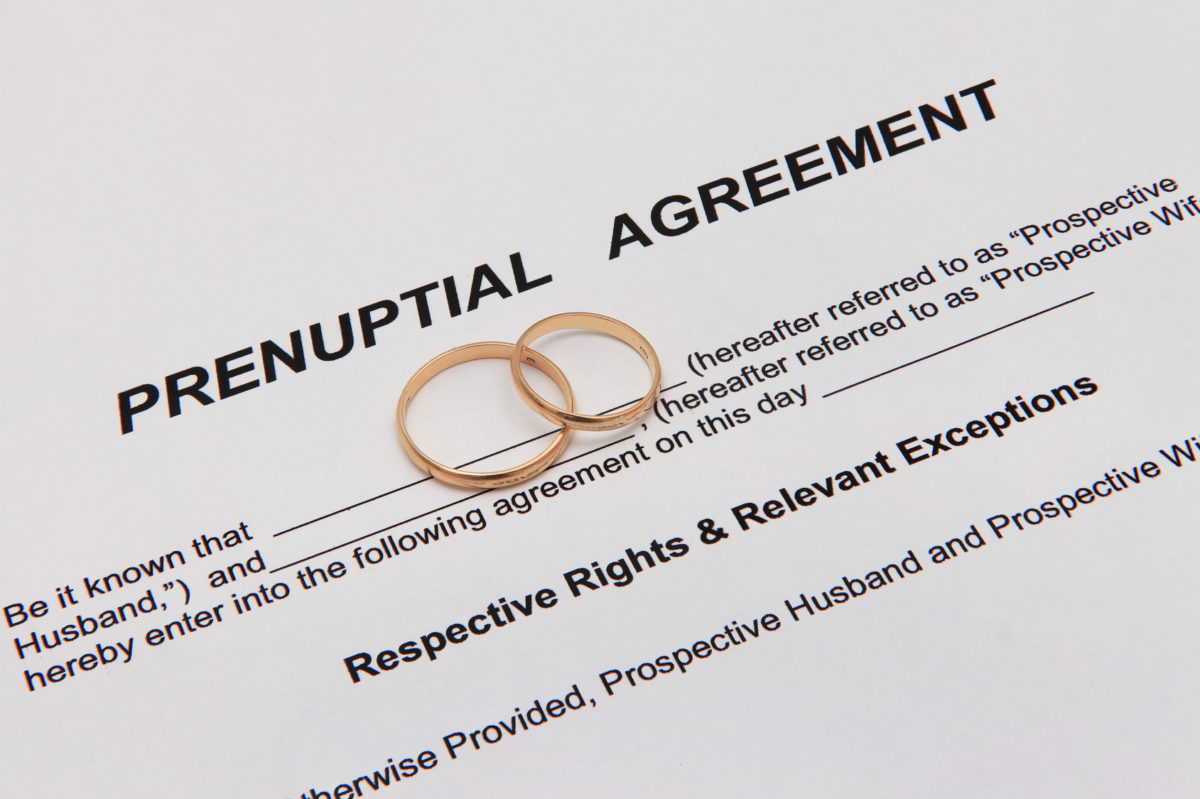 Prenuptial agreement document with weddings rings representing how our Chicago divorce attorney can assist you with creating a prenup agreement