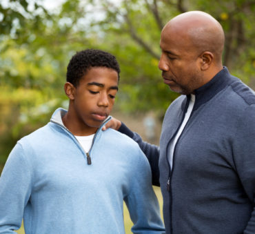 Father talking with his son representing how our Chicago divorce lawyers can assist you on the best ways to discuss divorce with your children.