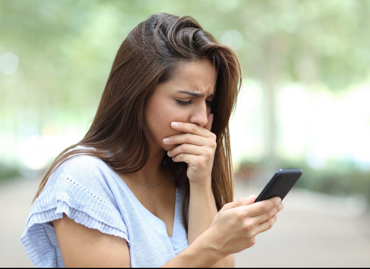 Woman checking her phone texts, if feeling like you are being harassed by ex via texting meet with your Chicago family law attorney.