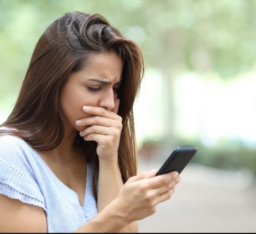 Woman checking her phone texts, if feeling like you are being harassed by ex via texting meet with your Chicago family law attorney.