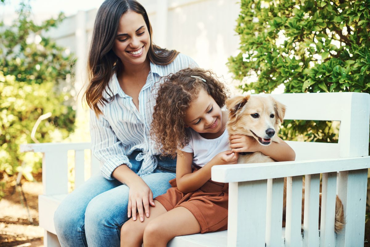 Mother with daughter and puppy sitting on outside bench, when looking for Chicago Child Custody Lawyer.