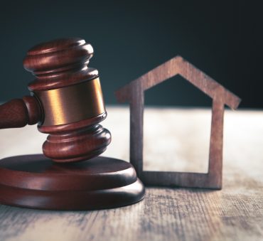 Judge gavel and houses on a wooden background. The concept of property division with the help of a Chicago Divorce Attorney.