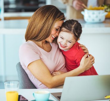 A mother with daughter embracing at table when looking for a good Child Custody Lawyer Chicago.